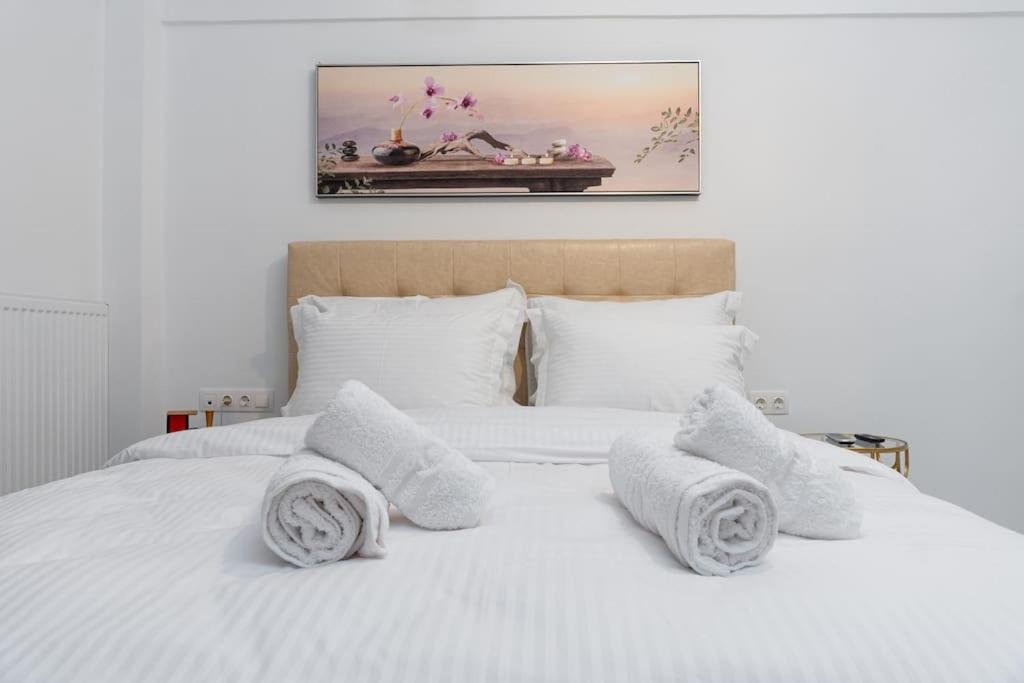 a bedroom with a white bed with towels on it at Serenity apartment in Thessaloniki