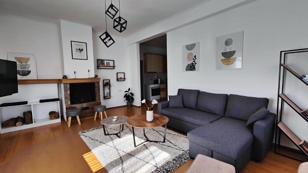 a living room with a blue couch and a table at Antonia's city apartment in Ioannina