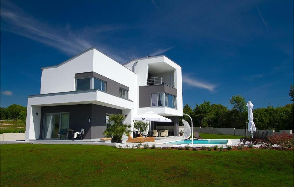 een wit huis met een zwembad ervoor bij Villa Windrose in Pula