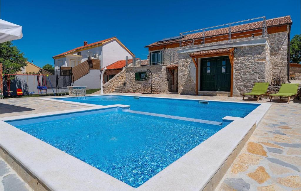 a swimming pool in front of a stone house at Villa Kunta in Zadar