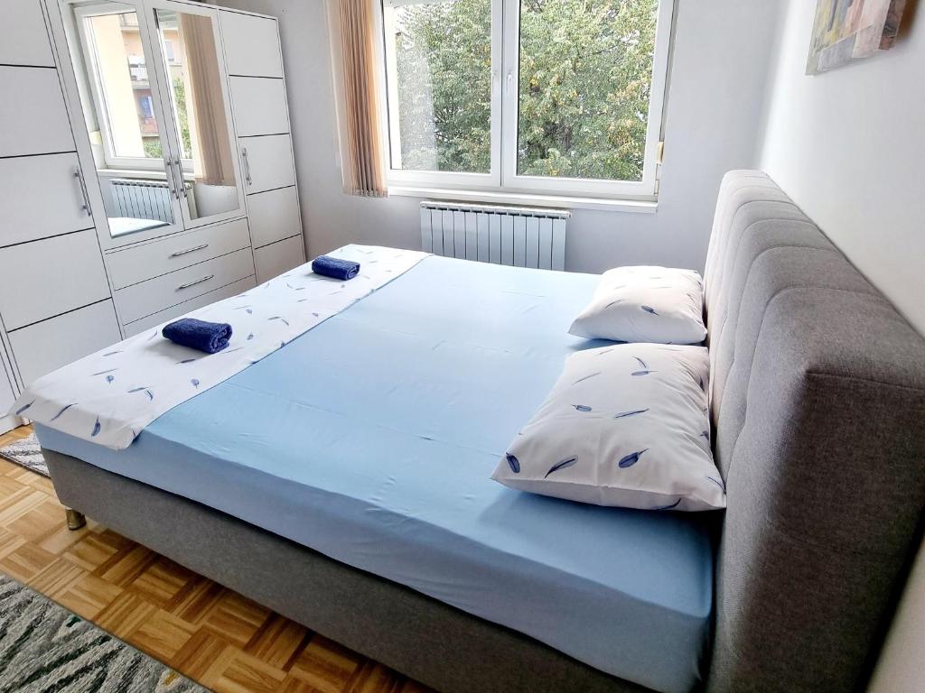 a bed in a room with a couch and two pillows at Garden House in Tuzla