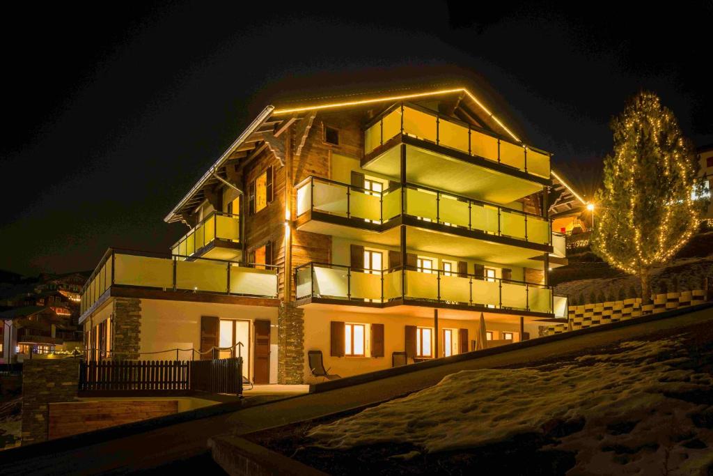 a large building with lights on it at night at B&B AZapartments Lunic in Grächen