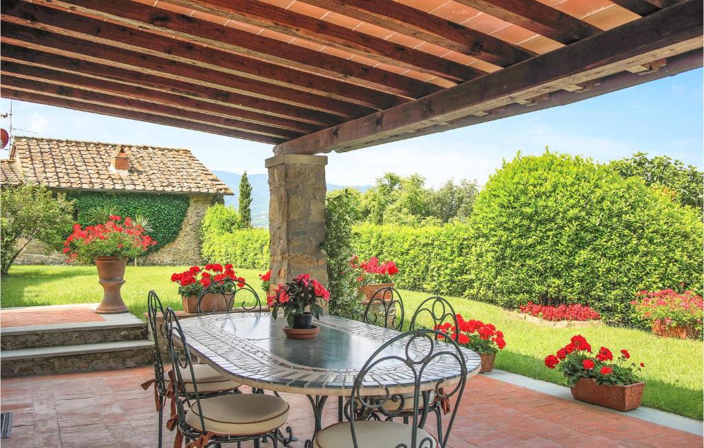 patio ze stołem, krzesłami i kwiatami w obiekcie La Terrazza Dei Frati w mieście Dicomano