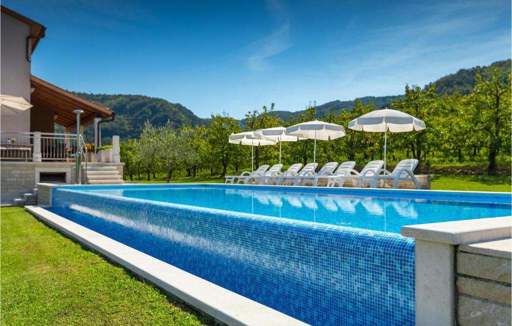 a swimming pool with chairs and umbrellas at Villa Alba in Motovun