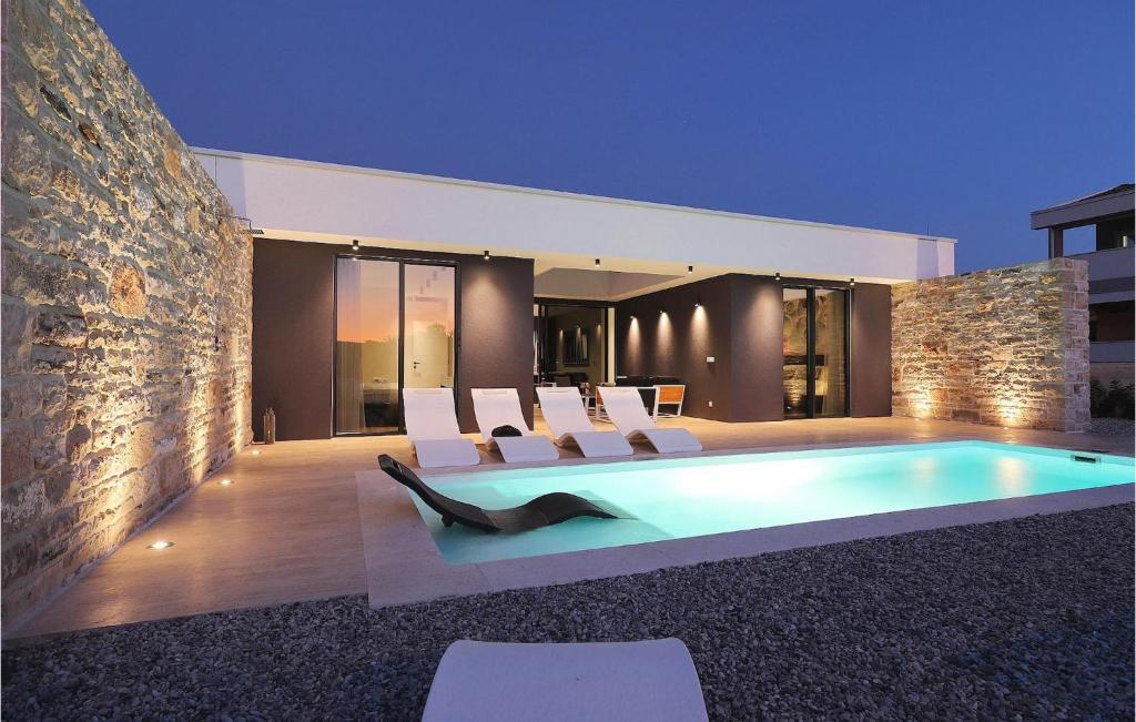 a house with a swimming pool with white chairs at Villa K4 in Zadar
