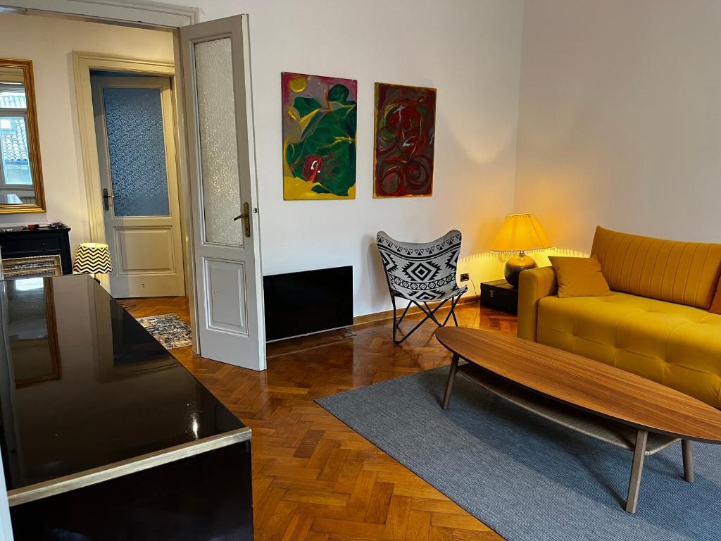 a living room with a yellow couch and a table at Emily in Trieste in San Vito