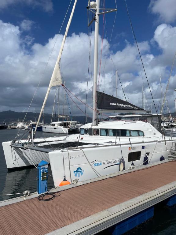 ビーゴにあるCatamaran Orionの白い船が桟橋に停泊