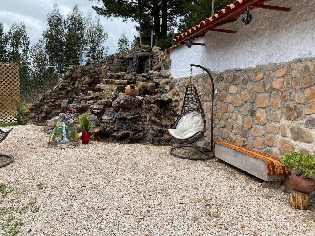 a garden with a stone wall and a swing at CasaBlanca Callacpuma in Cajamarca