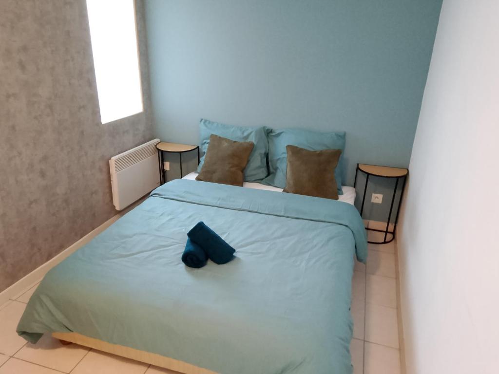 Un dormitorio con una cama azul con un arco azul. en Le Coin Cozy, en Carhaix-Plouguer