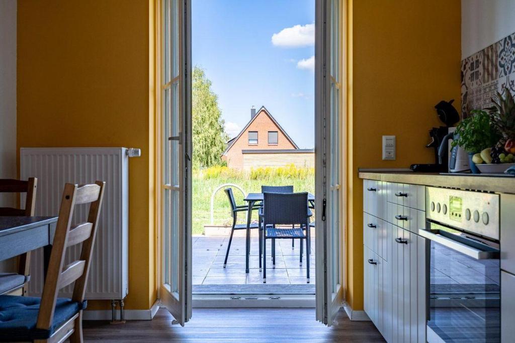 a kitchen with a door open to a patio with a table at Haus-kl-Mueritz in Rechlin