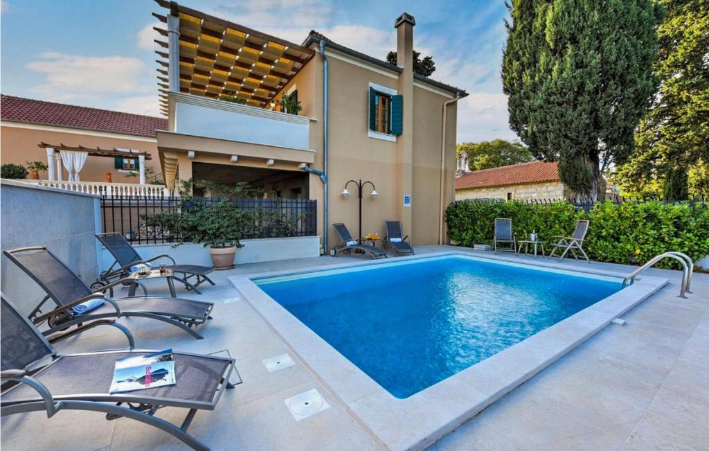 a swimming pool with chairs and a house at Villa Danica in Sukošan