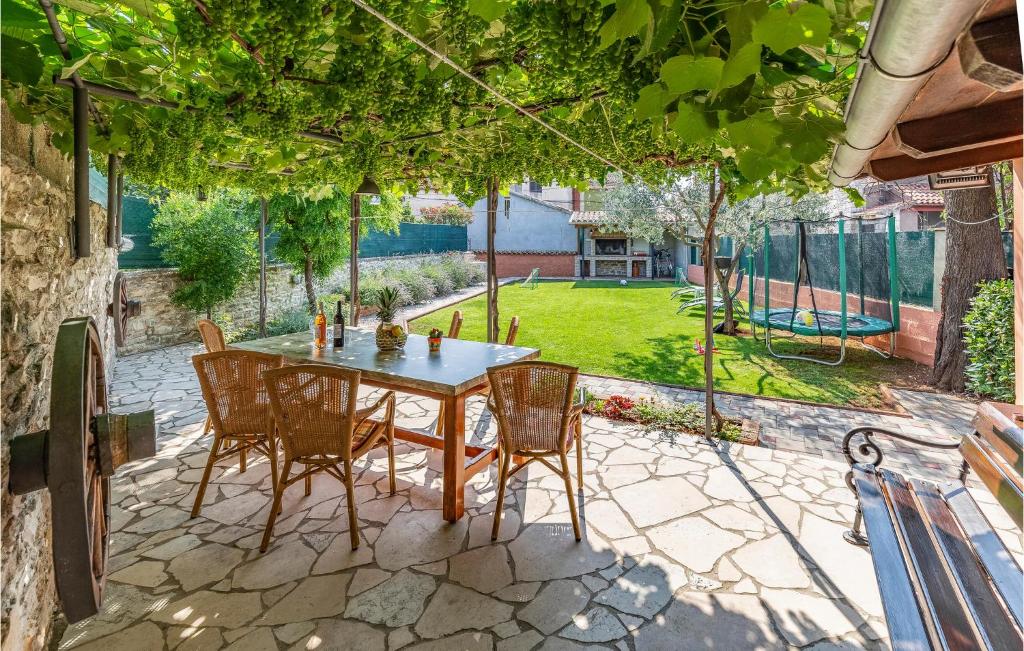 a patio with a table and chairs and a playground at Holiday Home Kavran - 08 in Kavran