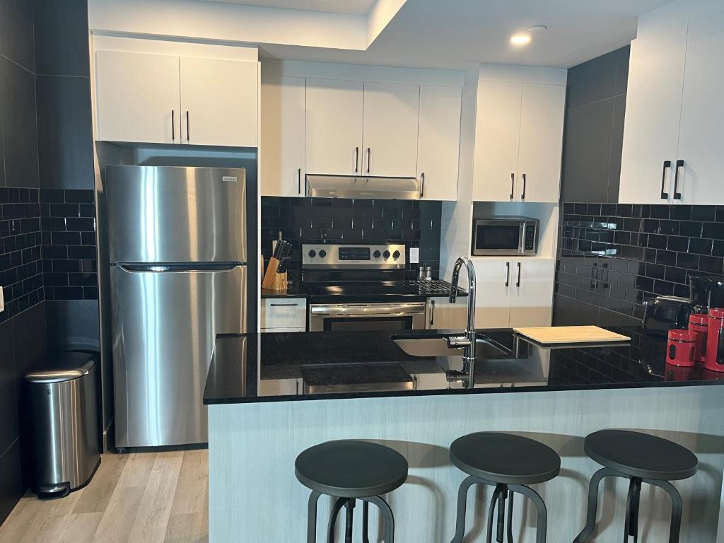 a kitchen with white cabinets and black counter tops at Joli condo en basse-ville - Parking gratuit 309357 in Quebec City