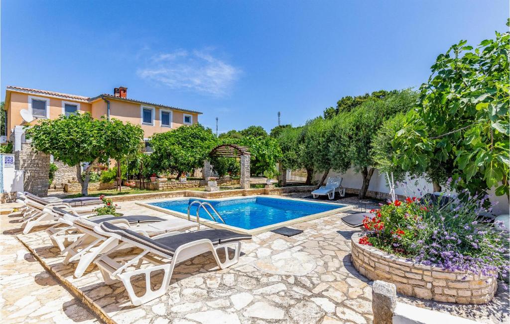 basen w ogrodzie z krzesłami i dom w obiekcie Holiday Home Medulin 33 w Medulinie