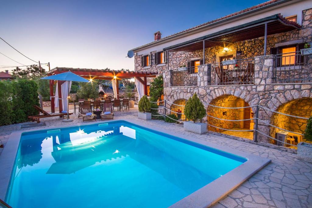a swimming pool in front of a house at Villa Vita in Polje