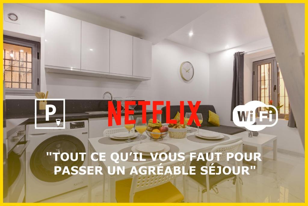 - une cuisine avec des placards blancs et une table avec un lave-vaisselle dans l'établissement Escapade Grassoise, à Grasse