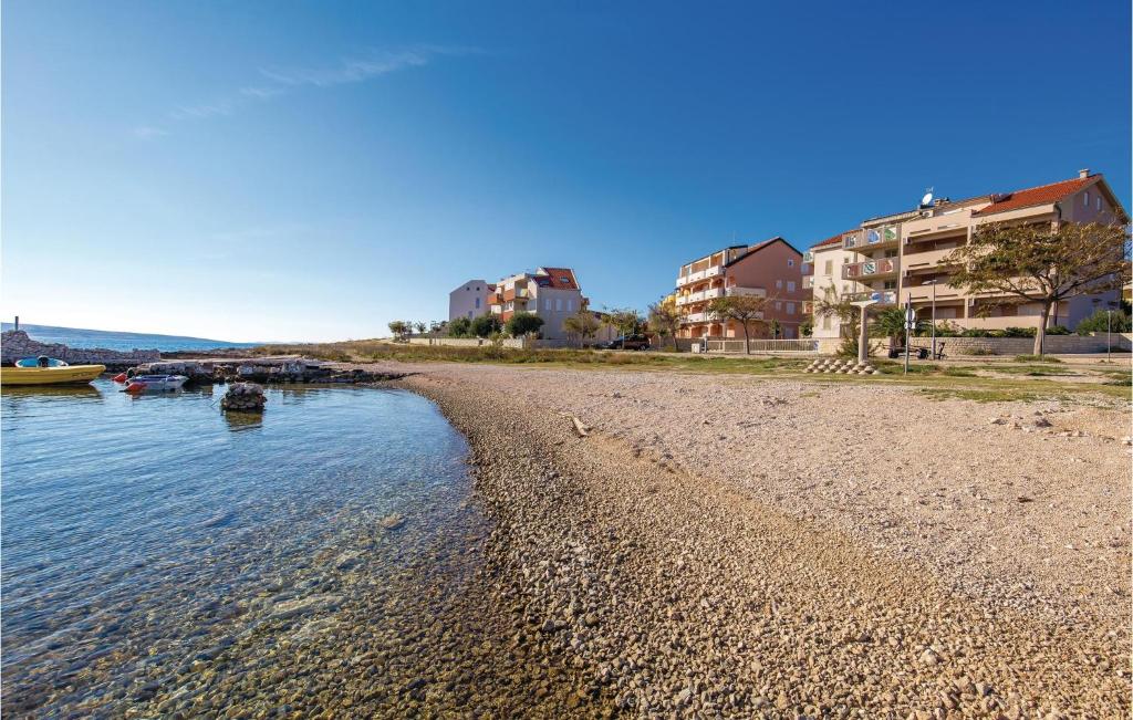a beach with some buildings and some water at Beautiful Apartment In Povljana in Povljana