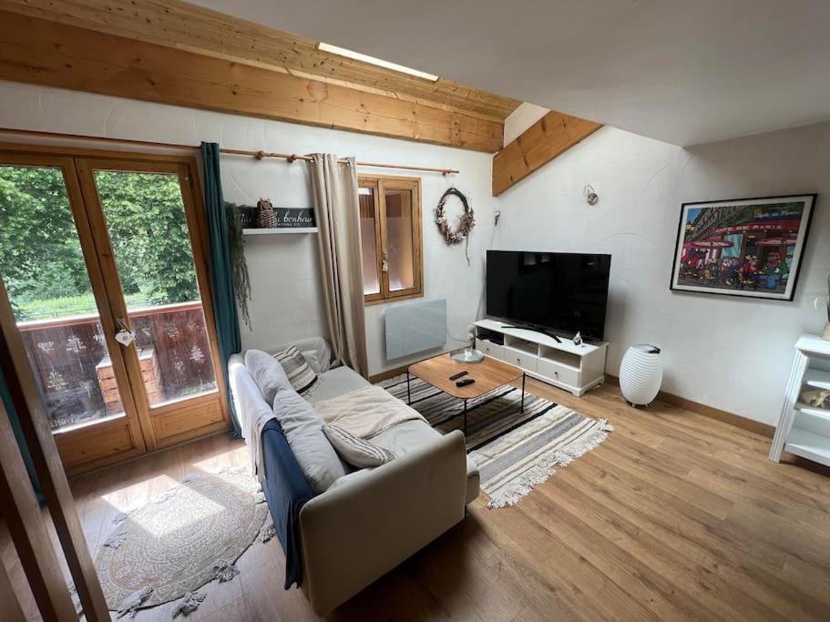 un salon avec un canapé et une télévision dans l'établissement Appartement cosy - 3 personnes, à Sainte-Foy-Tarentaise