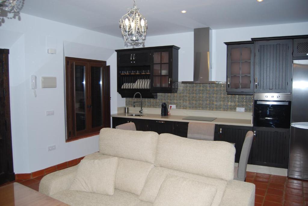 ein Wohnzimmer mit einem Sofa und einer Küche in der Unterkunft Apartamentos Bodeguetas in Constantina