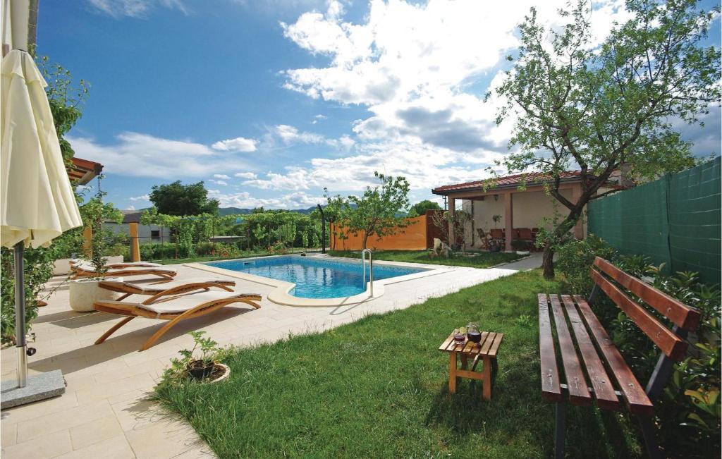 a backyard with a pool with a bench and a table at Apartment Sestanovac 23 With Outdoor Swimmingpool in Šestanovac