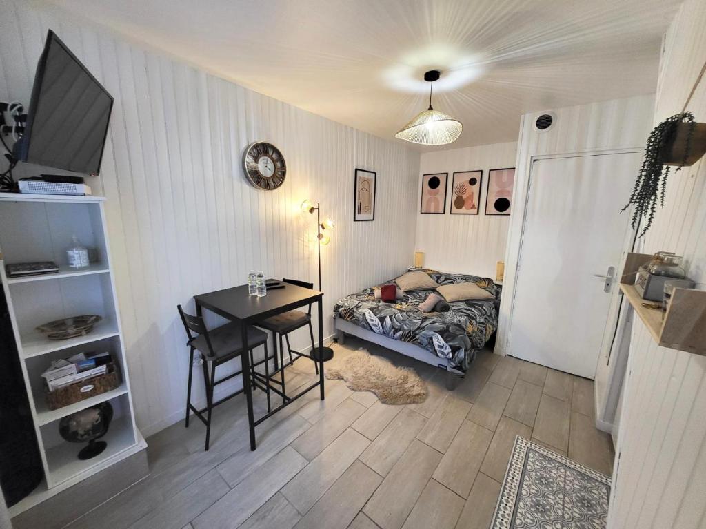 une chambre avec un bureau, un lit et une table dans l'établissement Studio cosy au cœur du quartier Saint-Pierre, à Amiens