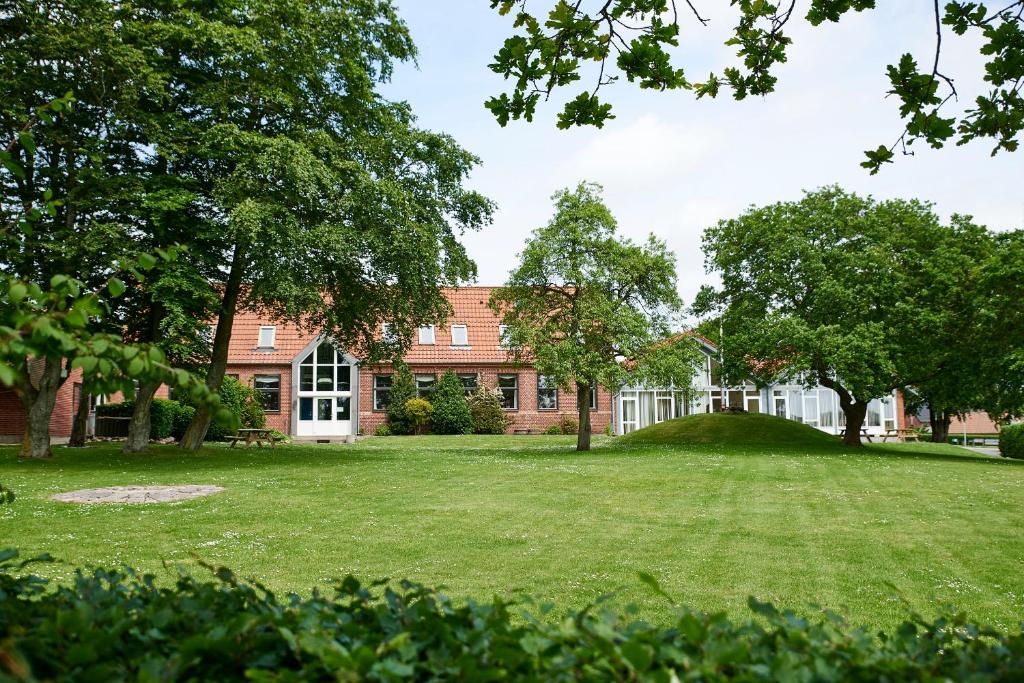 a large brick building with a large yard at KonceptHotel in Oksbøl