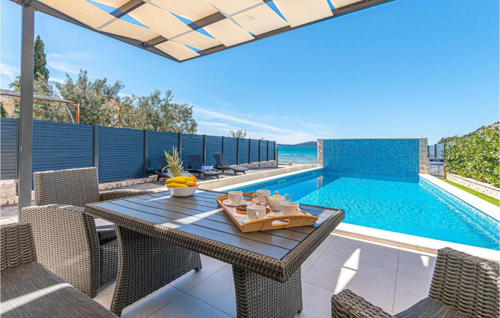 a patio with a table and chairs next to a swimming pool at Stunning Home In Sibenik - Zaboric in Zaboric