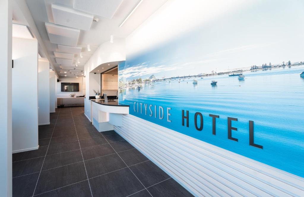 Un vestíbulo de oficina con un gran cartel de hotel en la pared en CitySide Hotel Tauranga, en Tauranga