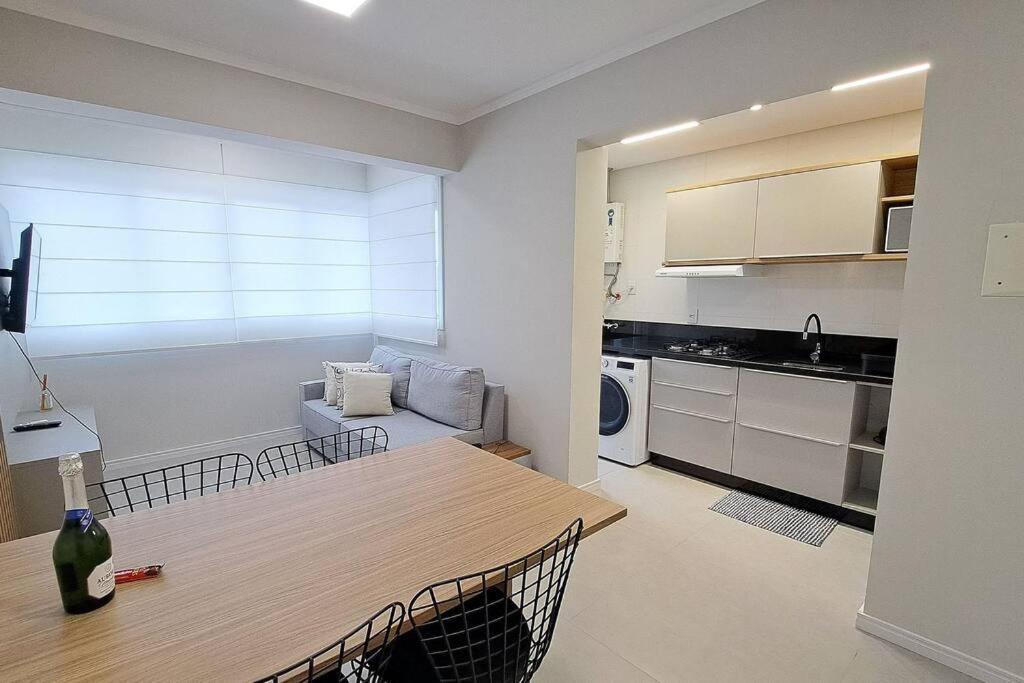 a living room with a table and a kitchen at Apartamento aconchegante próximo Maria Fumaça in Bento Gonçalves