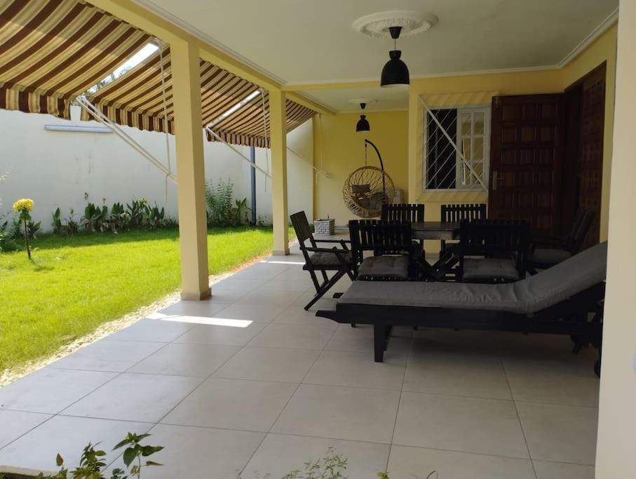 a patio with chairs and a table on a house at Charmante maison Riviera Golf Jardins in Abidjan