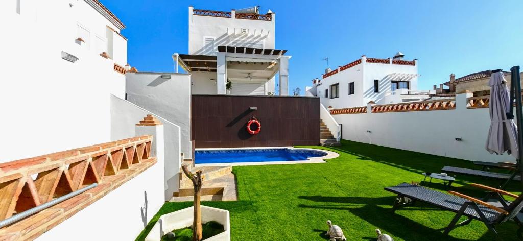 a backyard with a green lawn and a swimming pool at LUXURY VILLA ZAGARA GOLF & Pool in Estepona