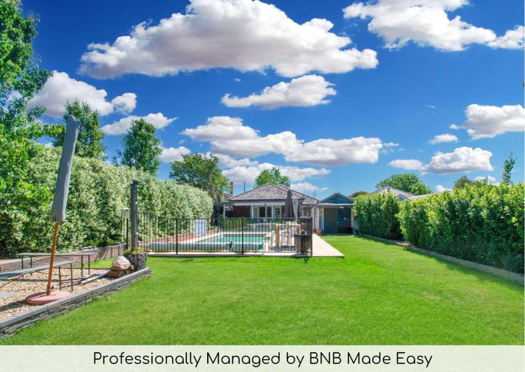 a yard with a fence and a playground at The Macleay - Poolside Entertainer, Pets Allowed in Wagga Wagga