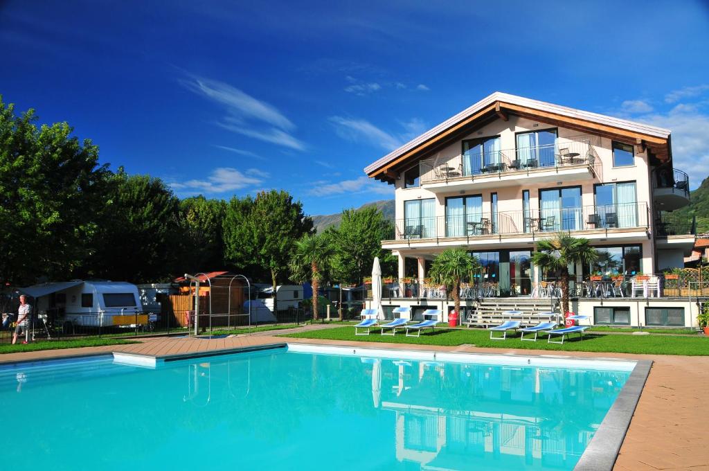 a house with a swimming pool in front of a house at Hotel Resort Le Vele in Domaso