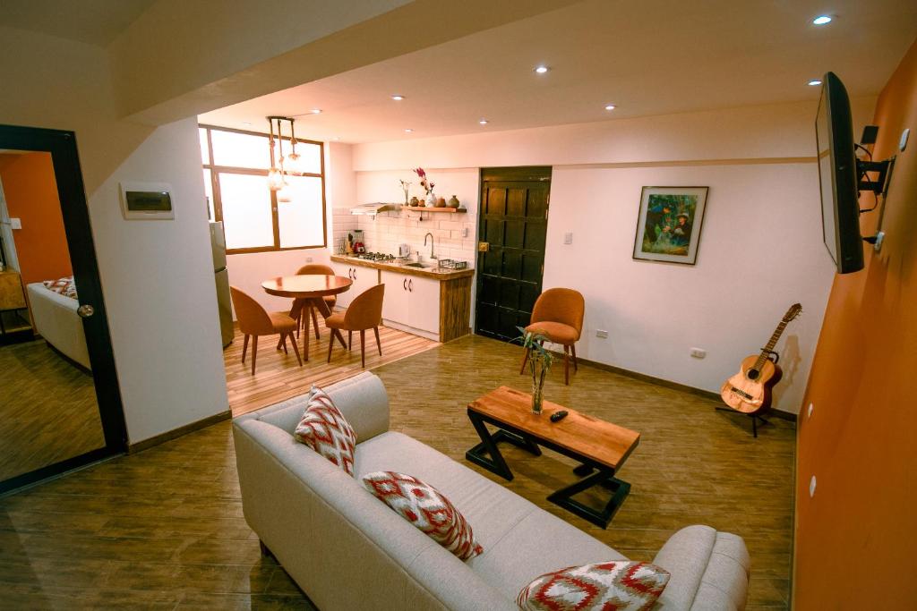 a living room with a couch and a table and a kitchen at Departamento Cumbe Mayo in Cajamarca
