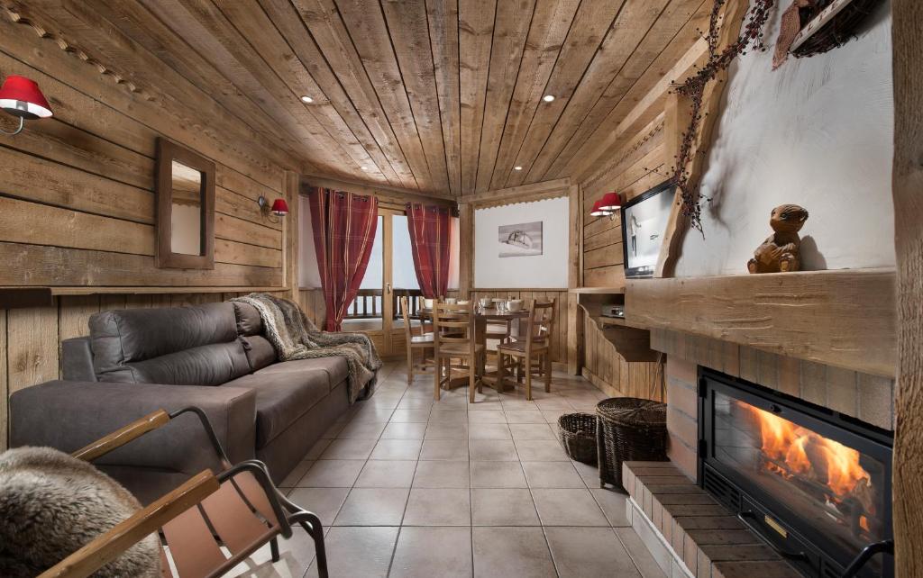 a living room with a couch and a fireplace at Ancolies Val Thorens in Val Thorens