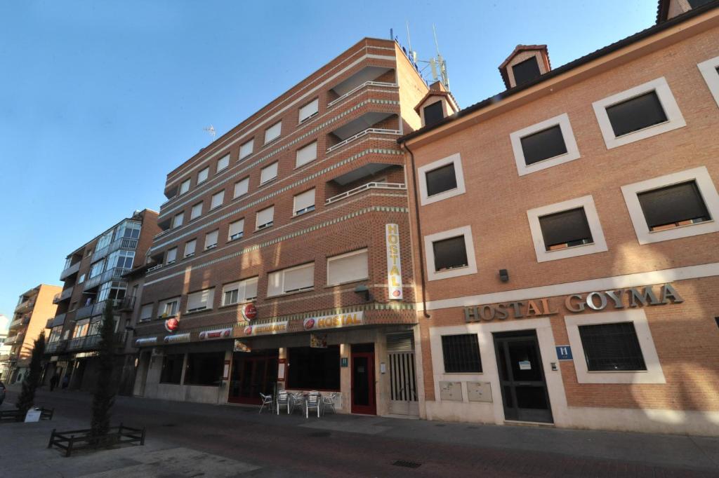 a tall brick building on a city street at Hostal Goyma I in San Fernando de Henares