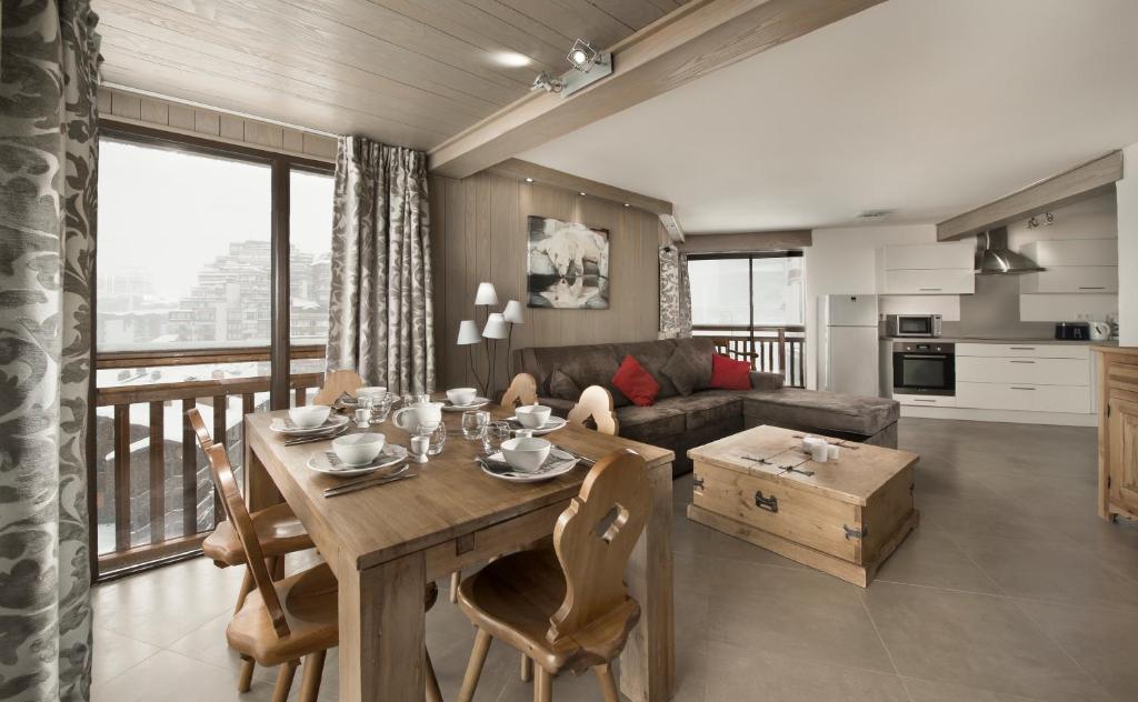 uma sala de estar com uma mesa e um sofá em A21 Roc de Péclet em Val Thorens