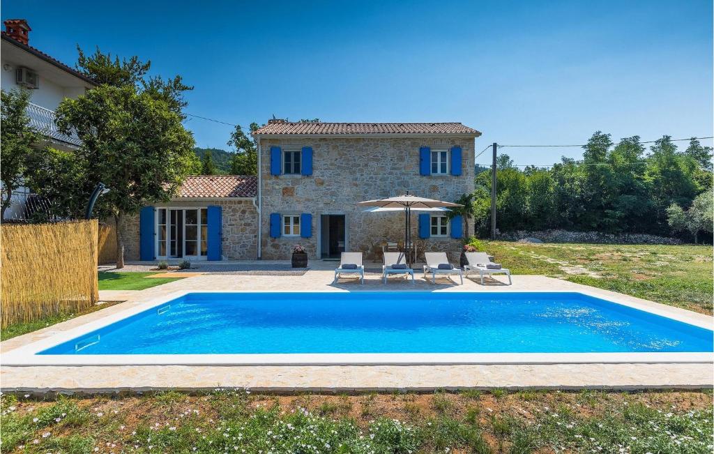 a villa with a swimming pool in front of a house at Villa Laura Ripenda in Ripenda Kras