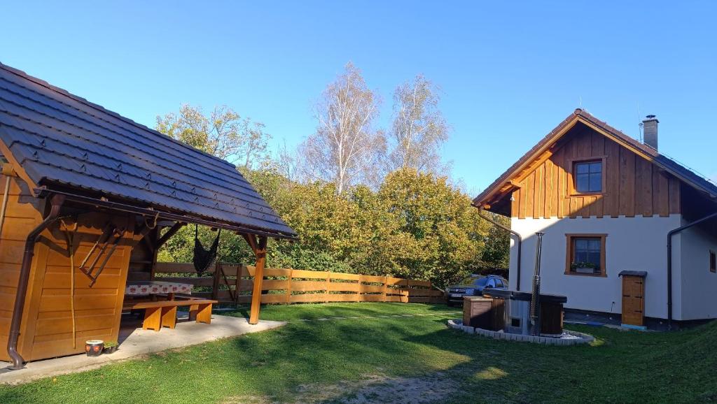 a barn with a picnic table next to a house at Dolná chata u Bratríkov in Haligovce