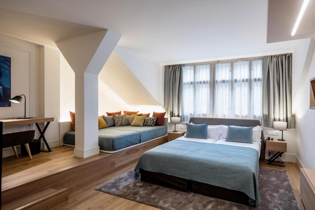 a hotel room with two beds and a desk at BoHo Prague Hotel - Small Luxury Hotels in Prague