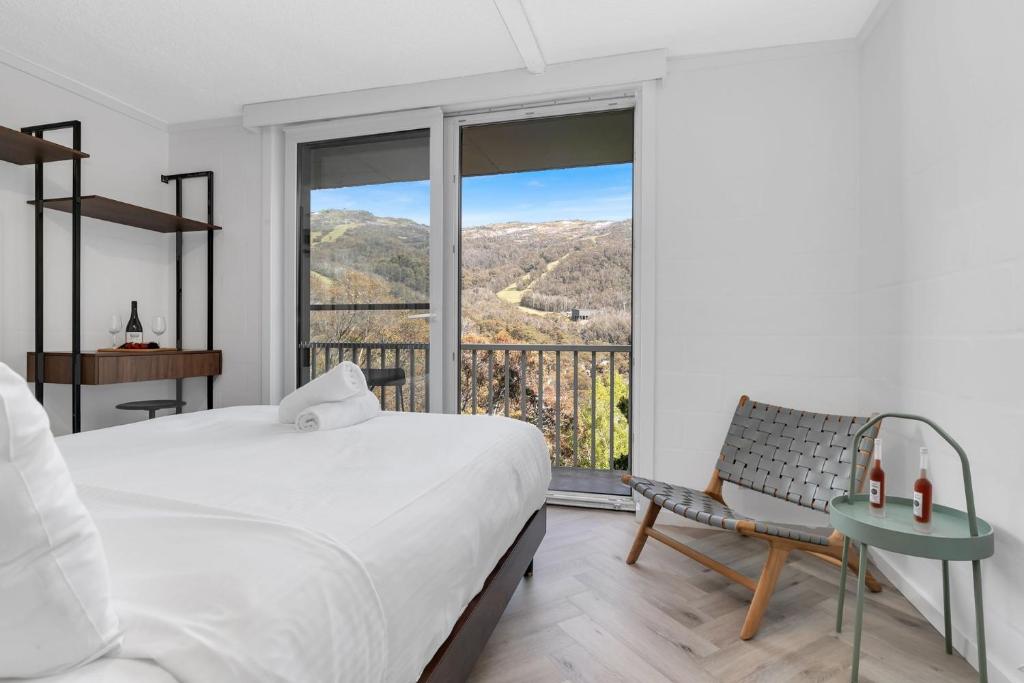 a bedroom with a bed and a balcony with a view at Byadbo 5 in Thredbo