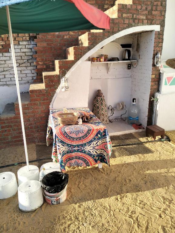 a room with a bed and a brick wall at Roma House in Aswan