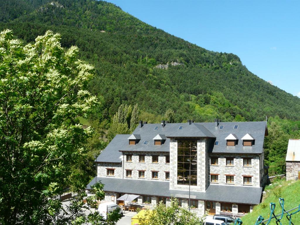 un edificio con una montaña en el fondo en Complejo Turístico Bielsa Hotel y camping en Bielsa