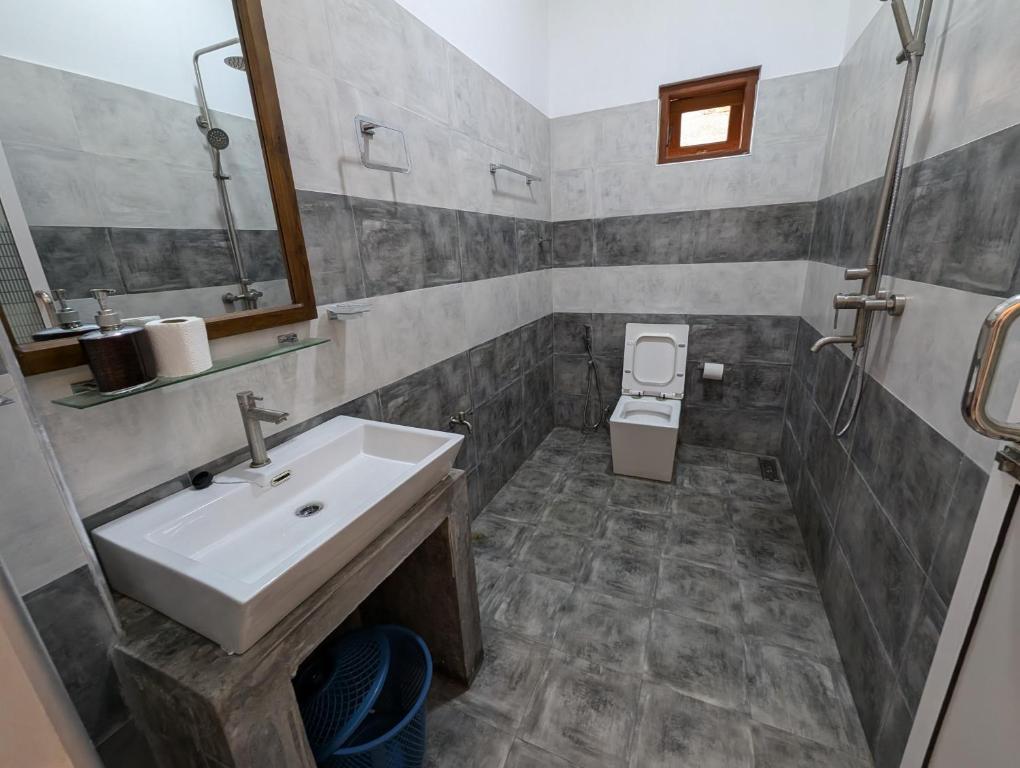a bathroom with a sink and a toilet at Costels Mirissa in Mirissa