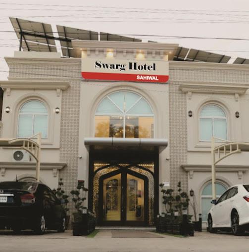 a smart hotel with cars parked in front of it at Swarg Hotel in Sāhīwāl