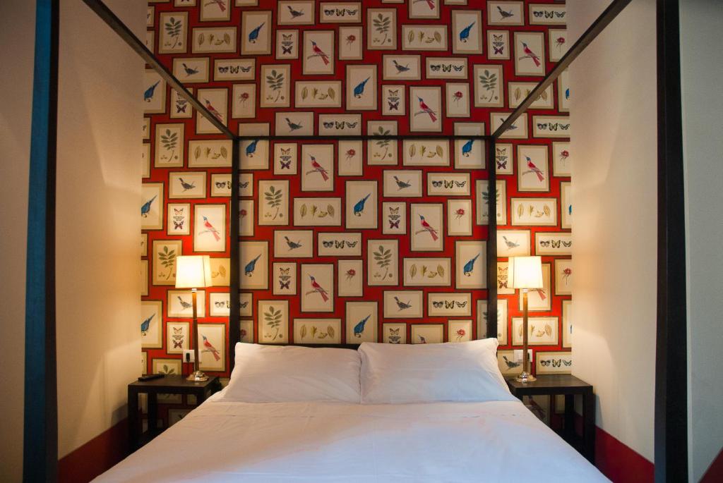 ein Schlafzimmer mit einer Wand aus Bildern an der Wand in der Unterkunft Black 5 Florence in Florenz