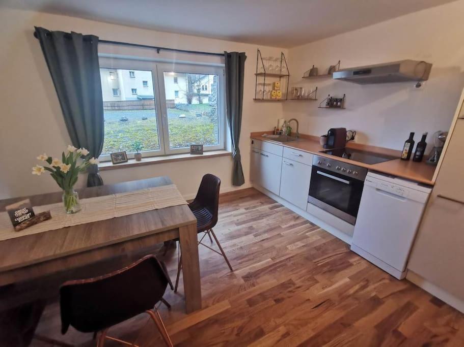 a kitchen with a wooden table and a wooden floor at Apartment Prinzip Hoffnung in Bürs