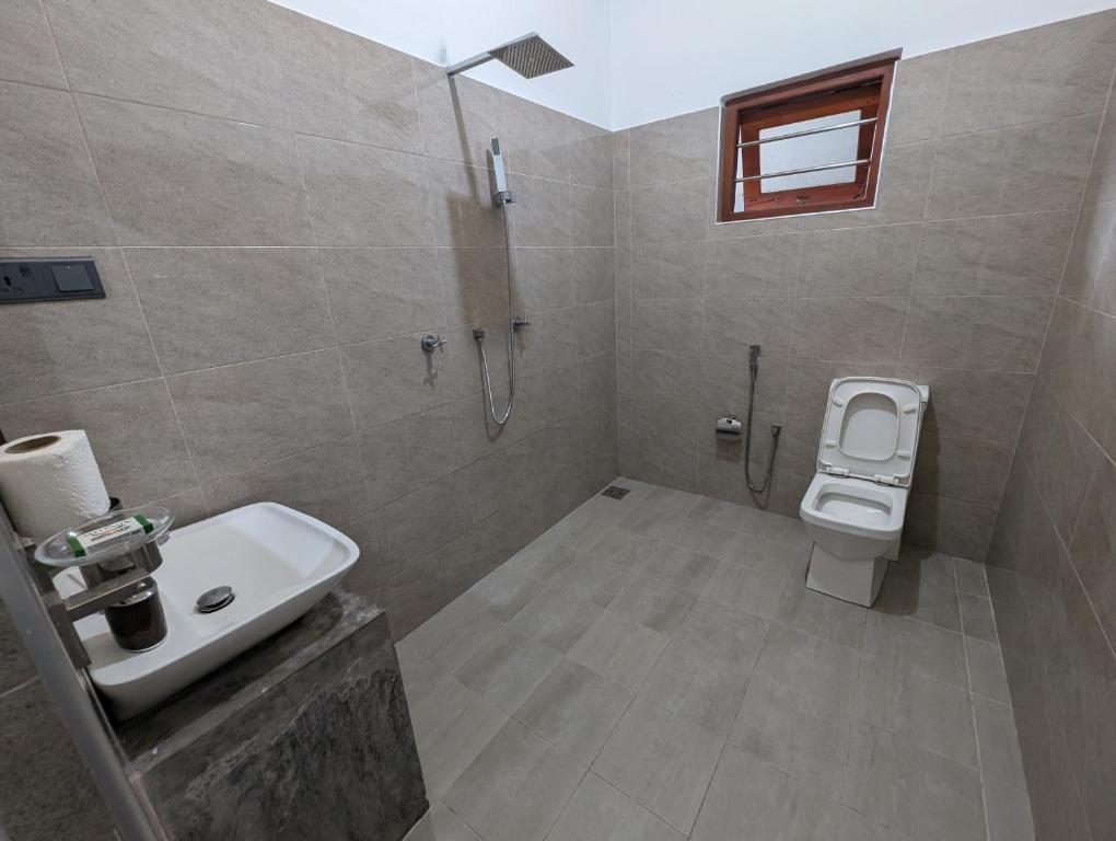 a bathroom with a sink and a toilet at Costels Mirissa in Mirissa