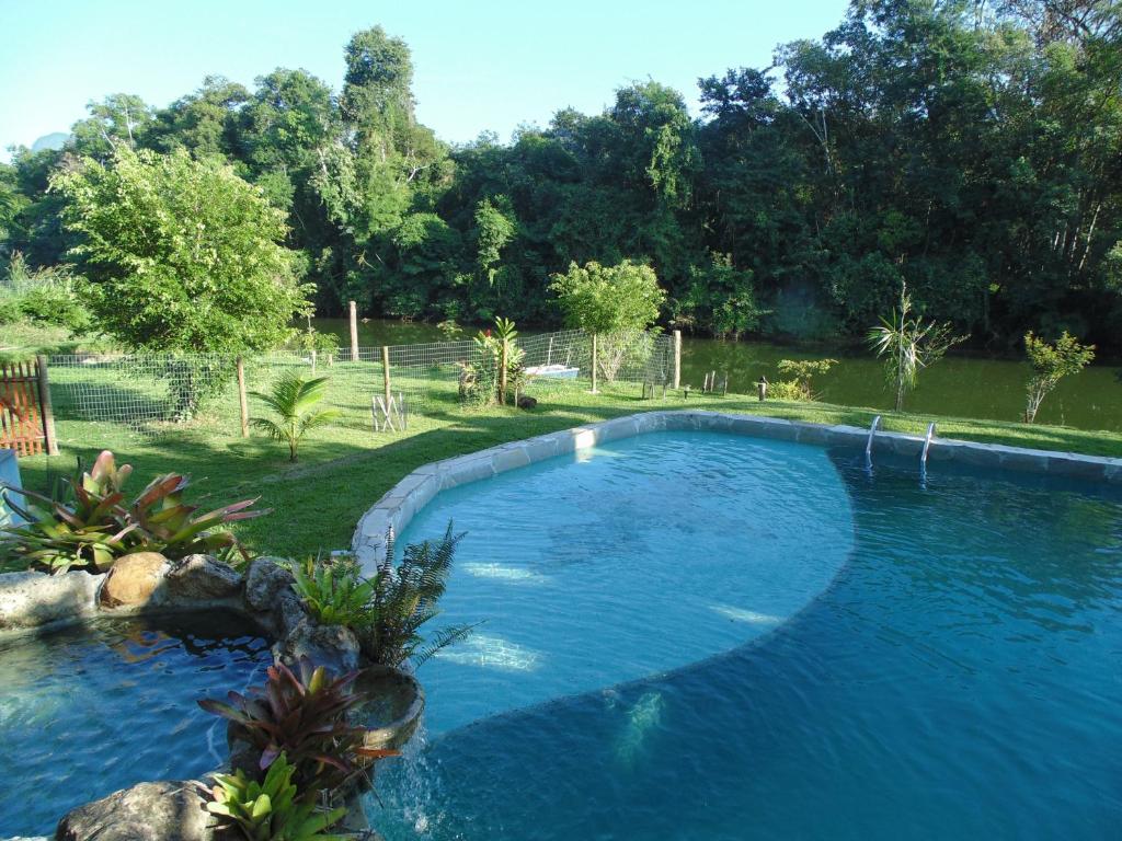 uma grande piscina azul num quintal em Pousada Magia Verde em Paraty