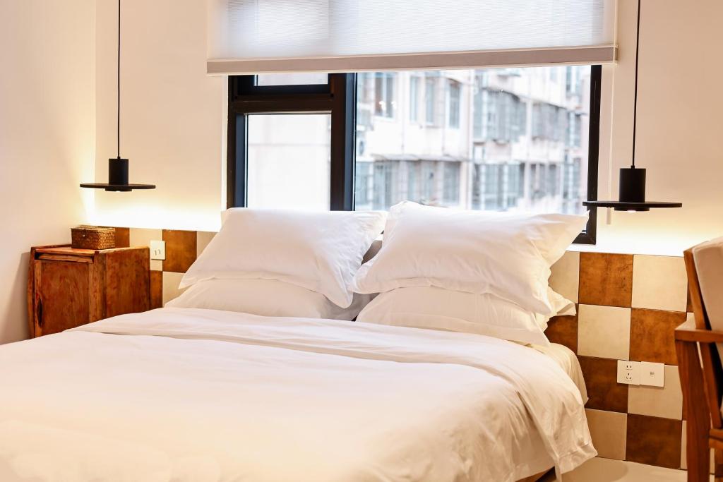 a bedroom with a white bed with a window at 三宝院子 in Jingdezhen